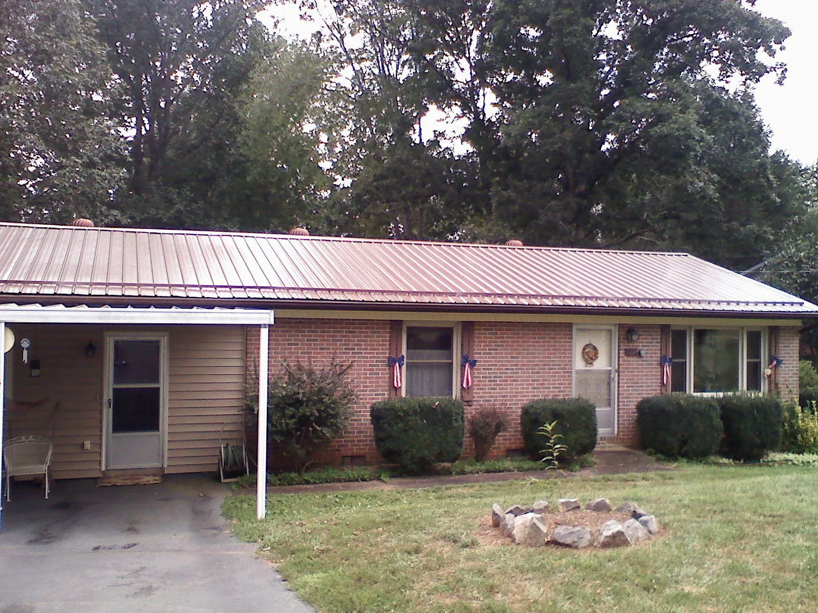 Bronze metal roof and carport on a brick ranch home — Roof Repair work by our crew in Hills